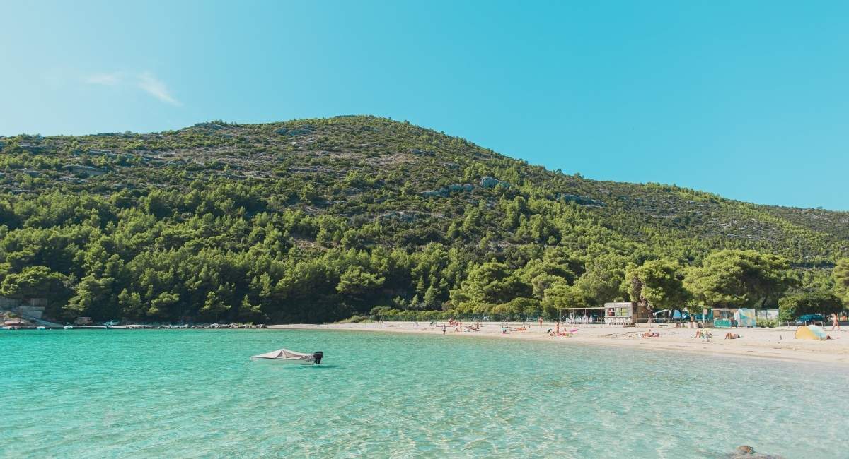 Plage de sable blanc et eau turquoise dans une crique des Baléares